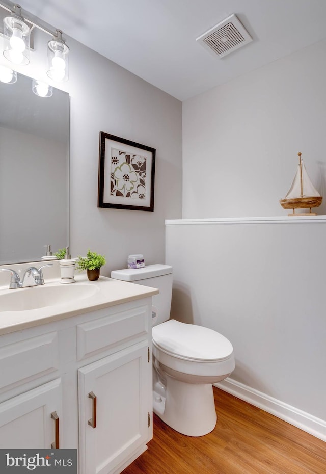 bathroom with vanity, wood-type flooring, and toilet