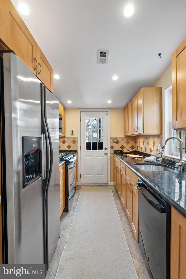 kitchen with light brown cabinetry, sink, light tile patterned flooring, and appliances with stainless steel finishes