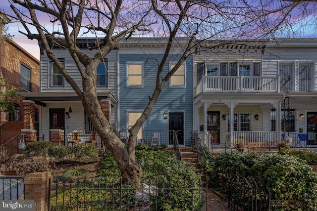 multi unit property featuring a balcony and covered porch