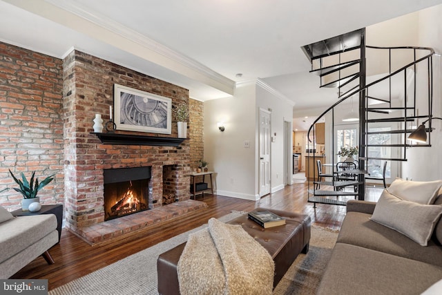 living room featuring hardwood / wood-style flooring, crown molding, and a fireplace