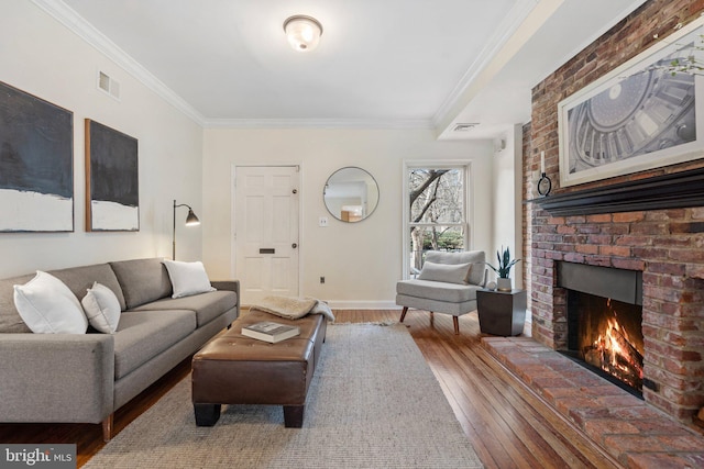 living room with crown molding, wood-type flooring, and a brick fireplace