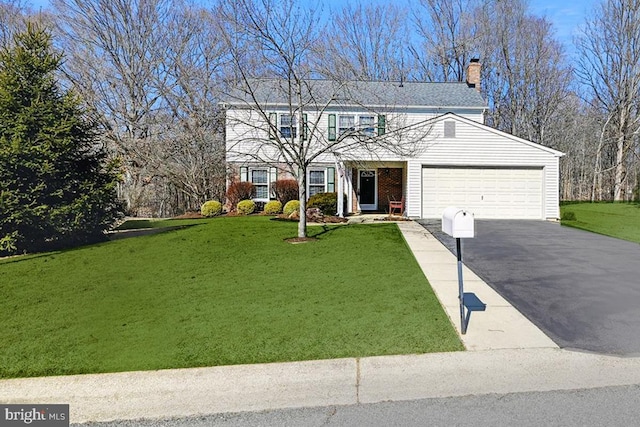 traditional-style home with aphalt driveway, an attached garage, a chimney, and a front lawn