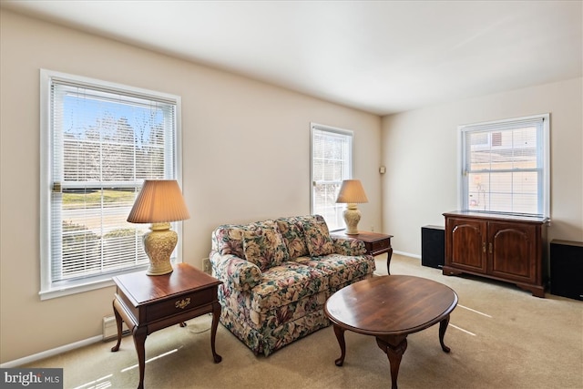 living area with light carpet and baseboards