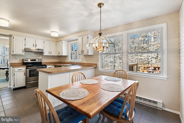 dining area with a notable chandelier, dark tile patterned floors, a baseboard heating unit, and baseboards