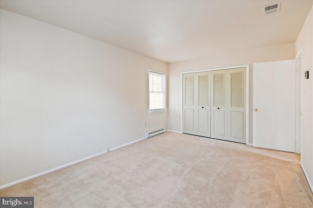 unfurnished bedroom featuring baseboards, visible vents, carpet floors, a baseboard heating unit, and a closet