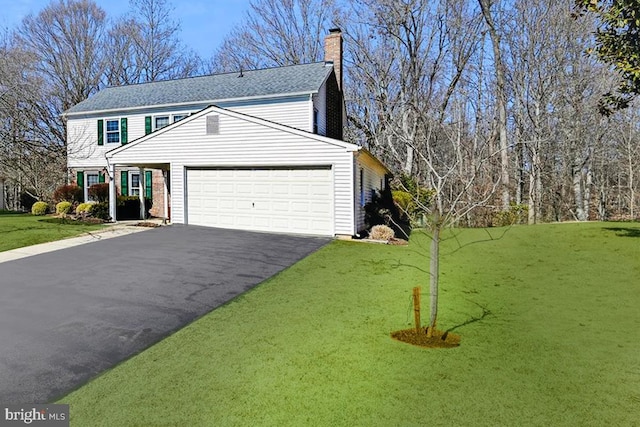 view of front of home with aphalt driveway, a front lawn, a chimney, and an attached garage