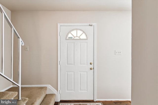 foyer featuring stairway and baseboards