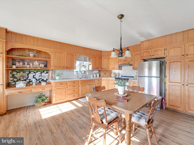 kitchen featuring light hardwood / wood-style floors, appliances with stainless steel finishes, hanging light fixtures, sink, and light brown cabinets