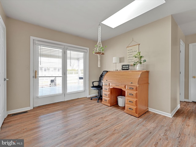 office area featuring light hardwood / wood-style floors and a skylight