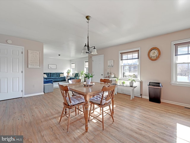 dining area featuring light wood-type flooring and a chandelier