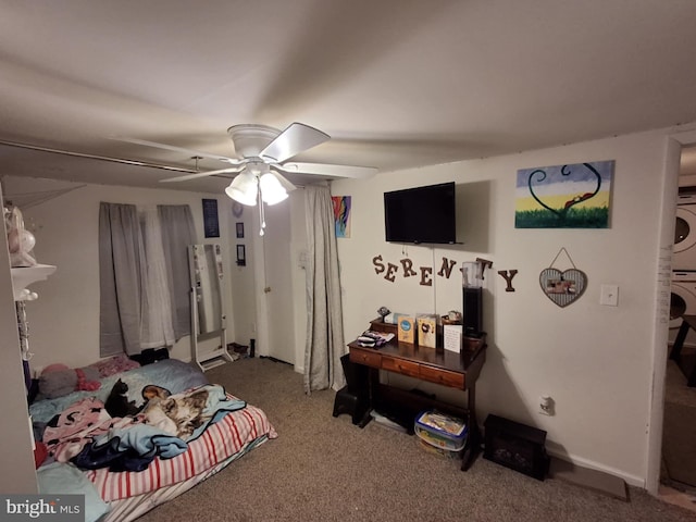 bedroom with carpet floors, stacked washer / dryer, and a ceiling fan