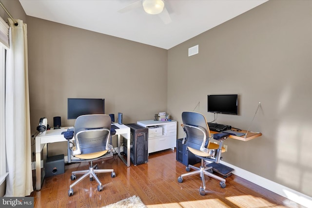 office with light wood-type flooring and ceiling fan