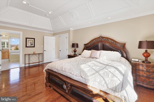 bedroom featuring hardwood / wood-style flooring, connected bathroom, and ornamental molding