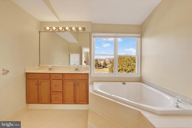 bathroom featuring tiled bath, vanity, and tile patterned flooring