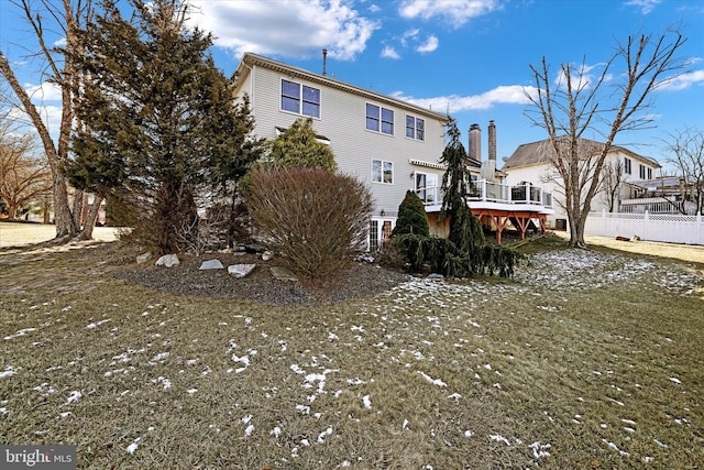 rear view of property with a lawn and a wooden deck