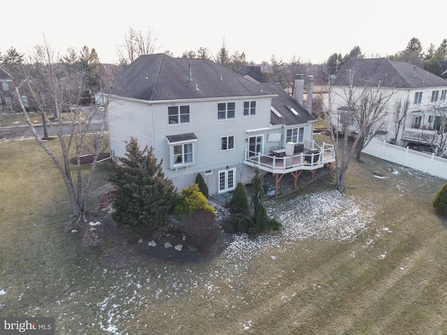 rear view of house with a wooden deck and a lawn