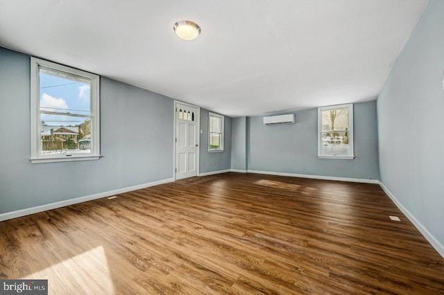 empty room featuring hardwood / wood-style floors and a wall mounted air conditioner