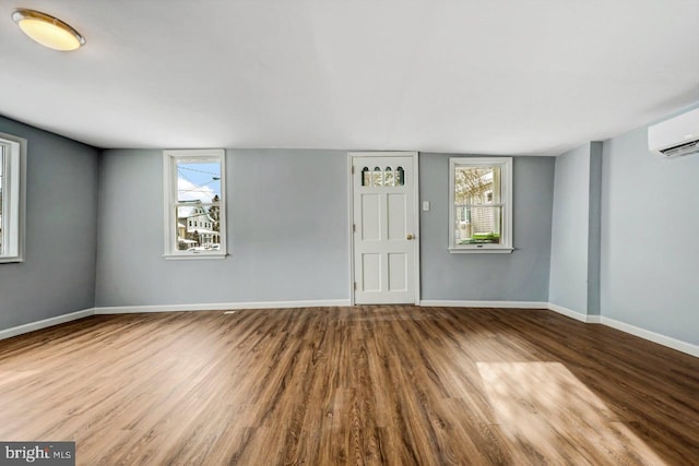 spare room featuring hardwood / wood-style flooring and a wall mounted air conditioner