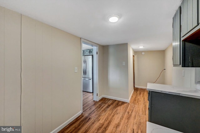 kitchen with hardwood / wood-style floors and stainless steel fridge