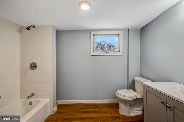 full bathroom featuring hardwood / wood-style floors, toilet, vanity, and tiled shower / bath