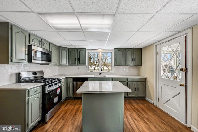 kitchen with tasteful backsplash, sink, a kitchen island, dark wood-type flooring, and stainless steel appliances