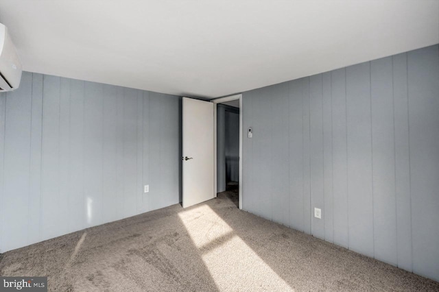 carpeted empty room with wood walls and a wall unit AC