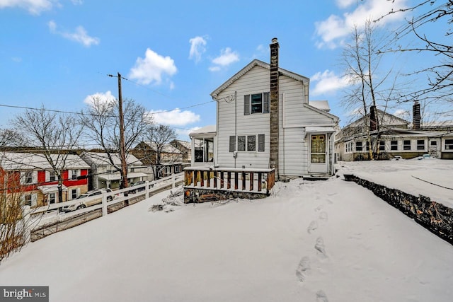 snow covered house featuring a porch