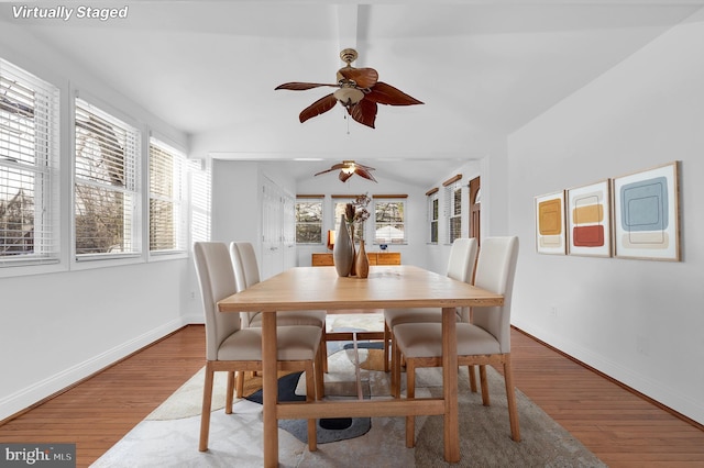 dining room featuring wood-type flooring and vaulted ceiling