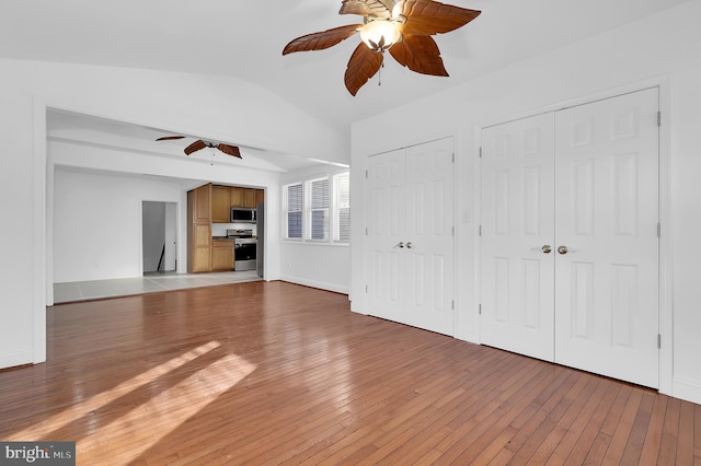 unfurnished living room featuring wood-type flooring, ceiling fan, and vaulted ceiling