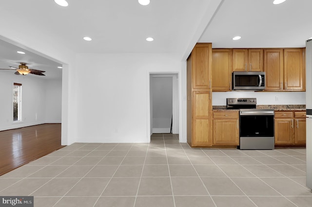 kitchen featuring stainless steel appliances, light tile patterned floors, and ceiling fan