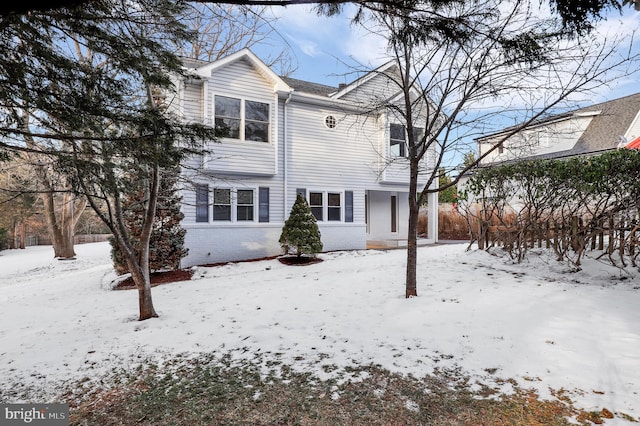 view of snow covered back of property