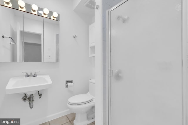 bathroom with tile patterned floors, toilet, a shower with shower door, and sink