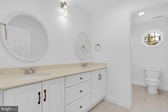 bathroom featuring tile patterned flooring, vanity, and toilet