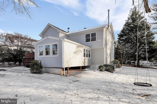 snow covered property featuring central AC