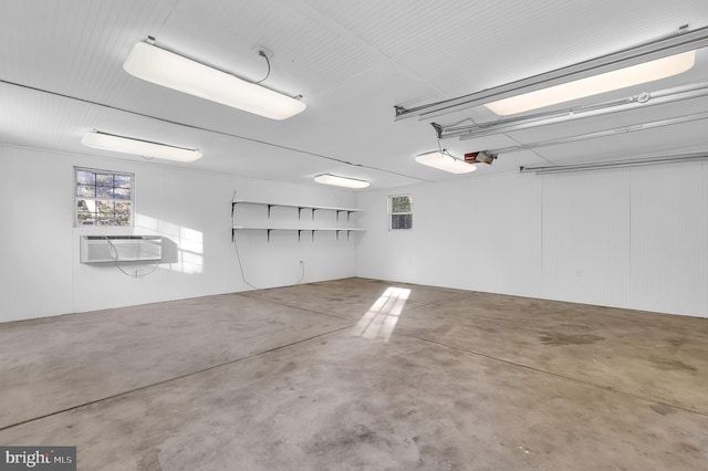 garage featuring a garage door opener and a wall mounted AC