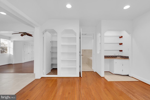 walk in closet featuring sink, light hardwood / wood-style floors, and ceiling fan