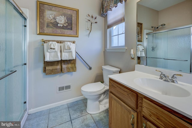 bathroom featuring toilet, a shower with shower door, tile patterned floors, and vanity