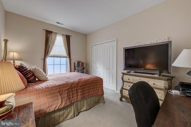 bedroom featuring light colored carpet and a closet