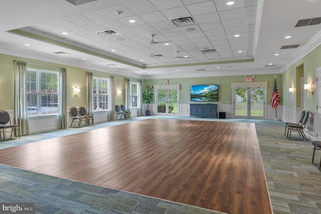 workout area featuring ornamental molding, french doors, and a raised ceiling