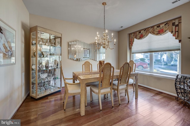 dining space featuring a notable chandelier and wood-type flooring