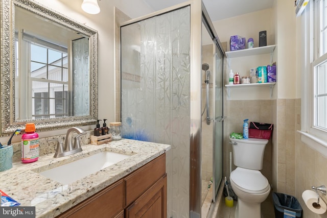 bathroom with tile walls, toilet, walk in shower, and vanity