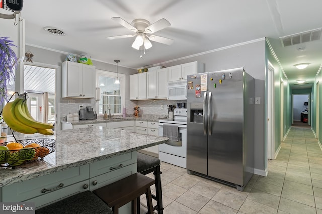 kitchen with white cabinetry, white appliances, light tile patterned floors, and hanging light fixtures