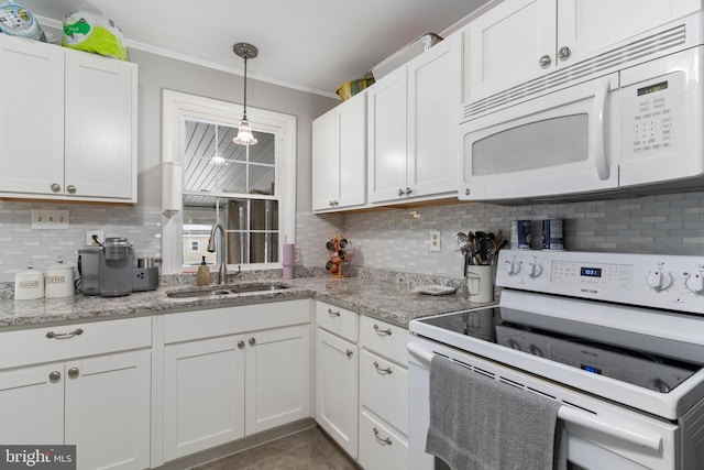 kitchen with light stone countertops, white cabinetry, sink, and white appliances