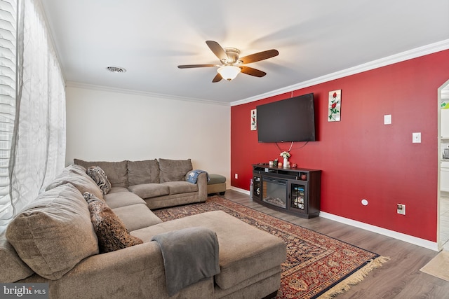 living room featuring hardwood / wood-style flooring, crown molding, and ceiling fan