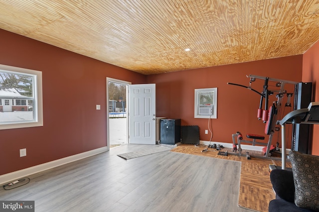 workout room featuring light hardwood / wood-style floors and wooden ceiling