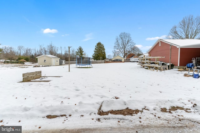 yard covered in snow with a trampoline