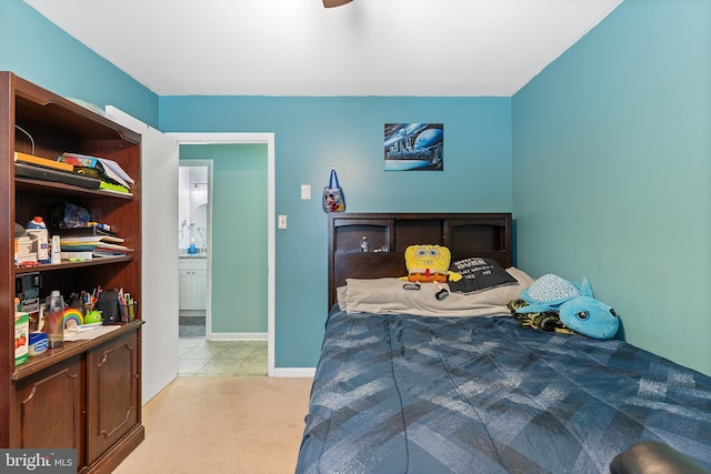 bedroom featuring light carpet, ceiling fan, and connected bathroom