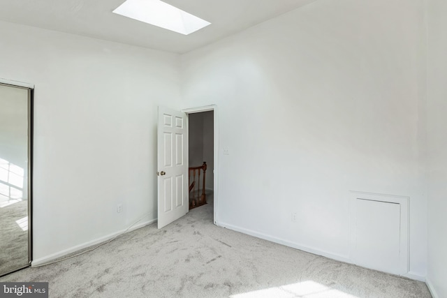 carpeted spare room with a skylight