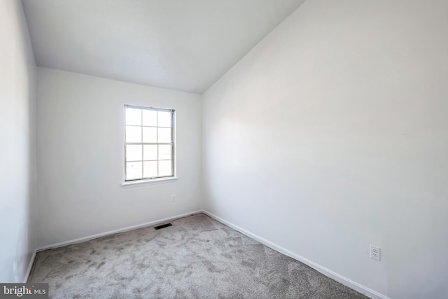 unfurnished room with vaulted ceiling and light colored carpet