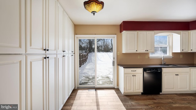 kitchen featuring dark wood-type flooring, sink, white cabinetry, and black dishwasher